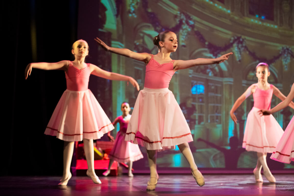 Groupe de jeunes ballerines qui dansent sur scène en costume rose