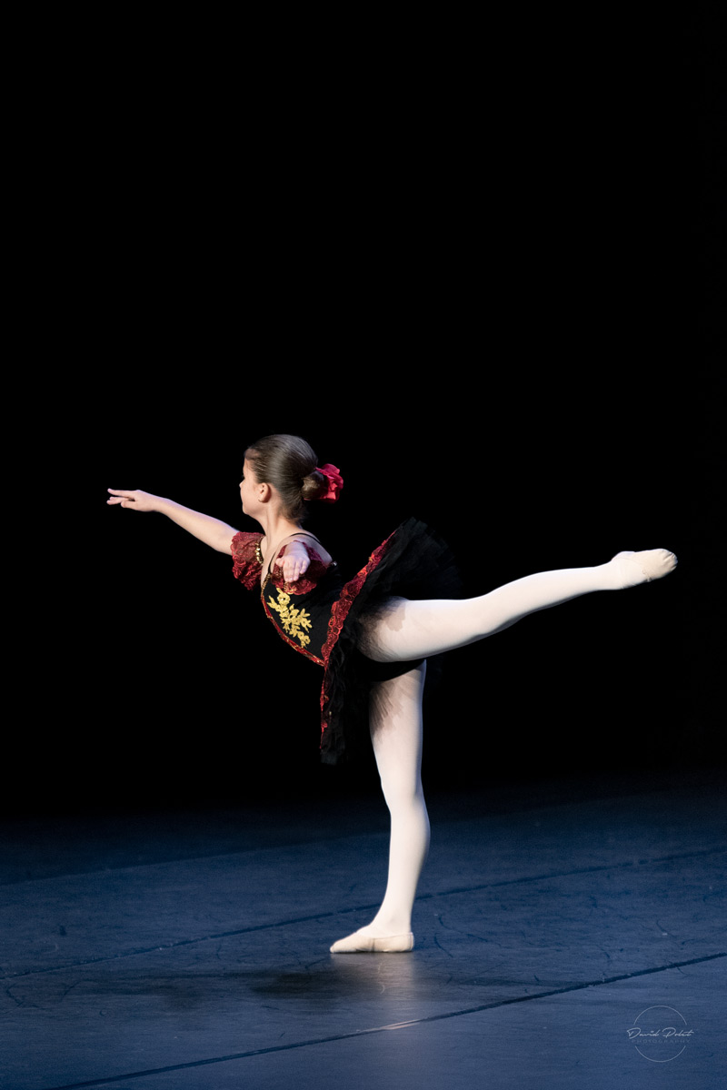 Une jeune danseuse réalise une arabesque