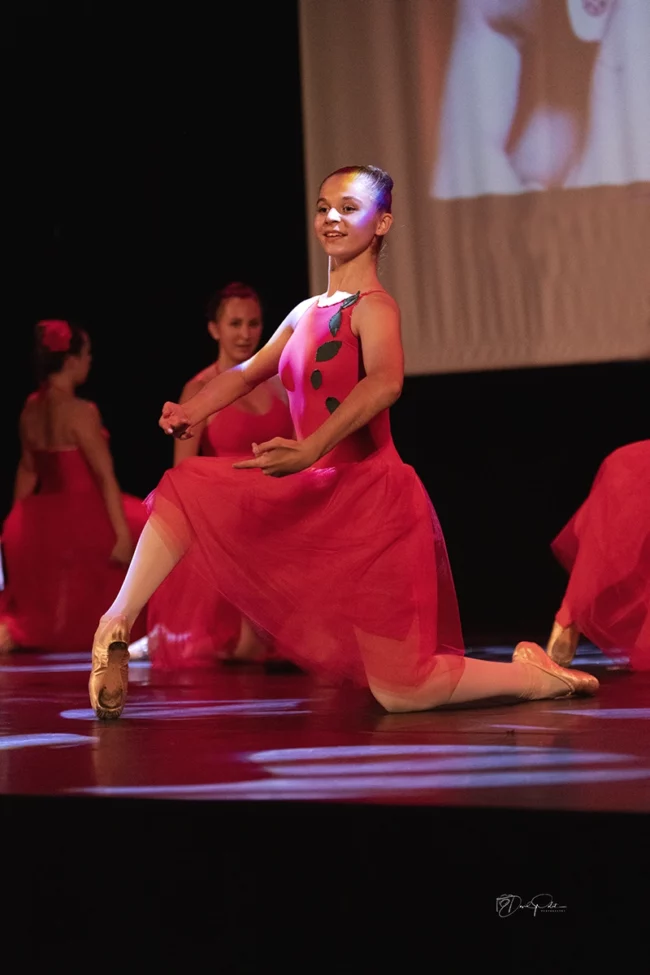 Lucille Polet en costume rouge réalise une prestation de danse classique élégante