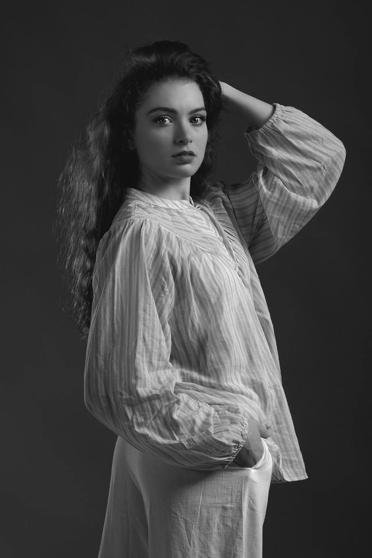 portrait-studio-mode-david-polet-photgoraphy Portrait de femme en vêtement ample, cheveux bouclés, regardant l'objectif, photographie par David Polet, photographe mode.