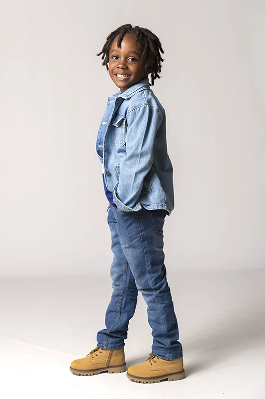 Portrait d'un enfant souriant en tenue denim, capturé en studio par David POLET Photographe, spécialiste des shootings photo à Nice et Villeneuve Loubet.