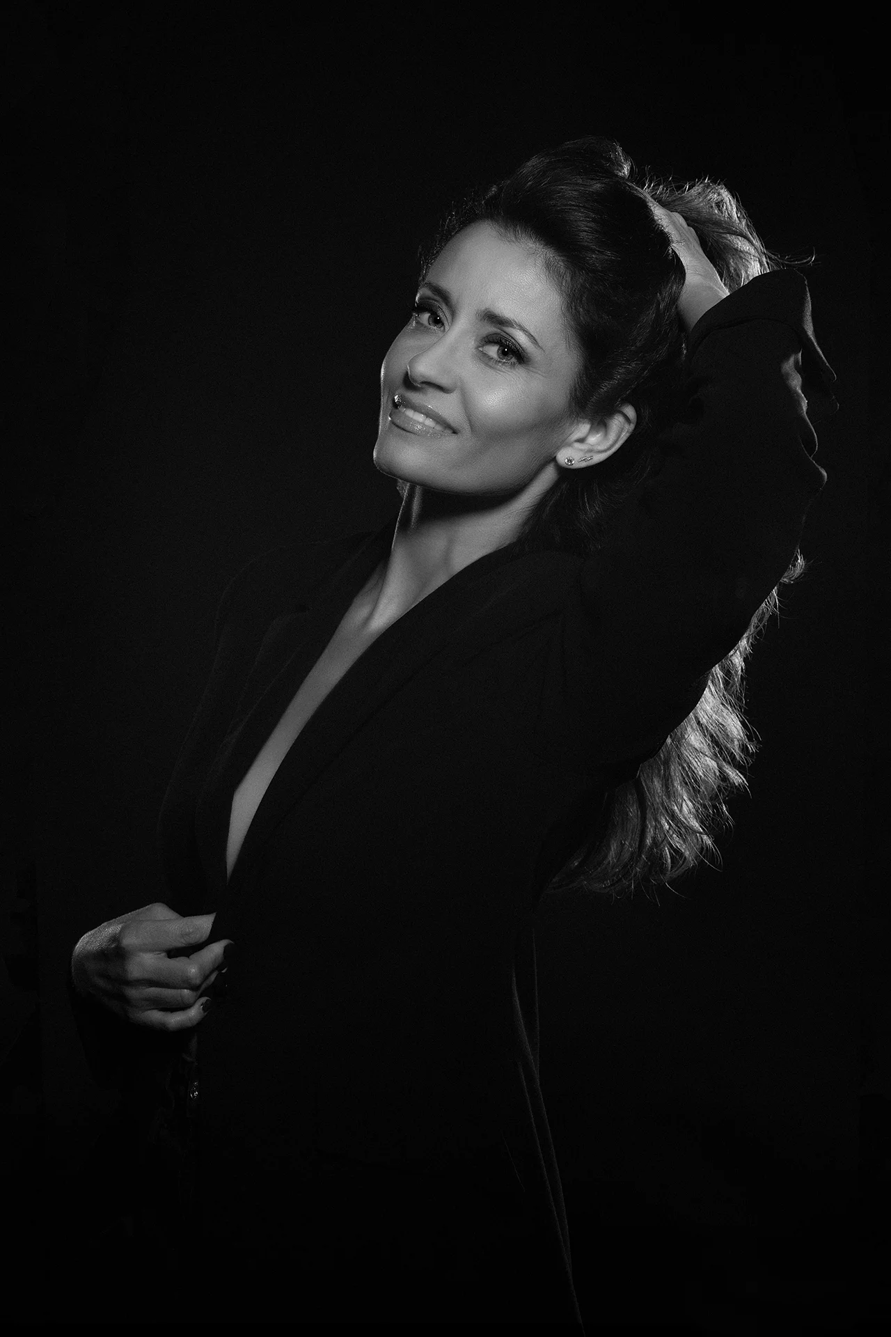 portrait-glamour-studio-david-polet-photography Portrait glamour, capturé par David Polet, photographe portrait, femme souriante, cheveux bouclés, vêtue d'un blazer chic.