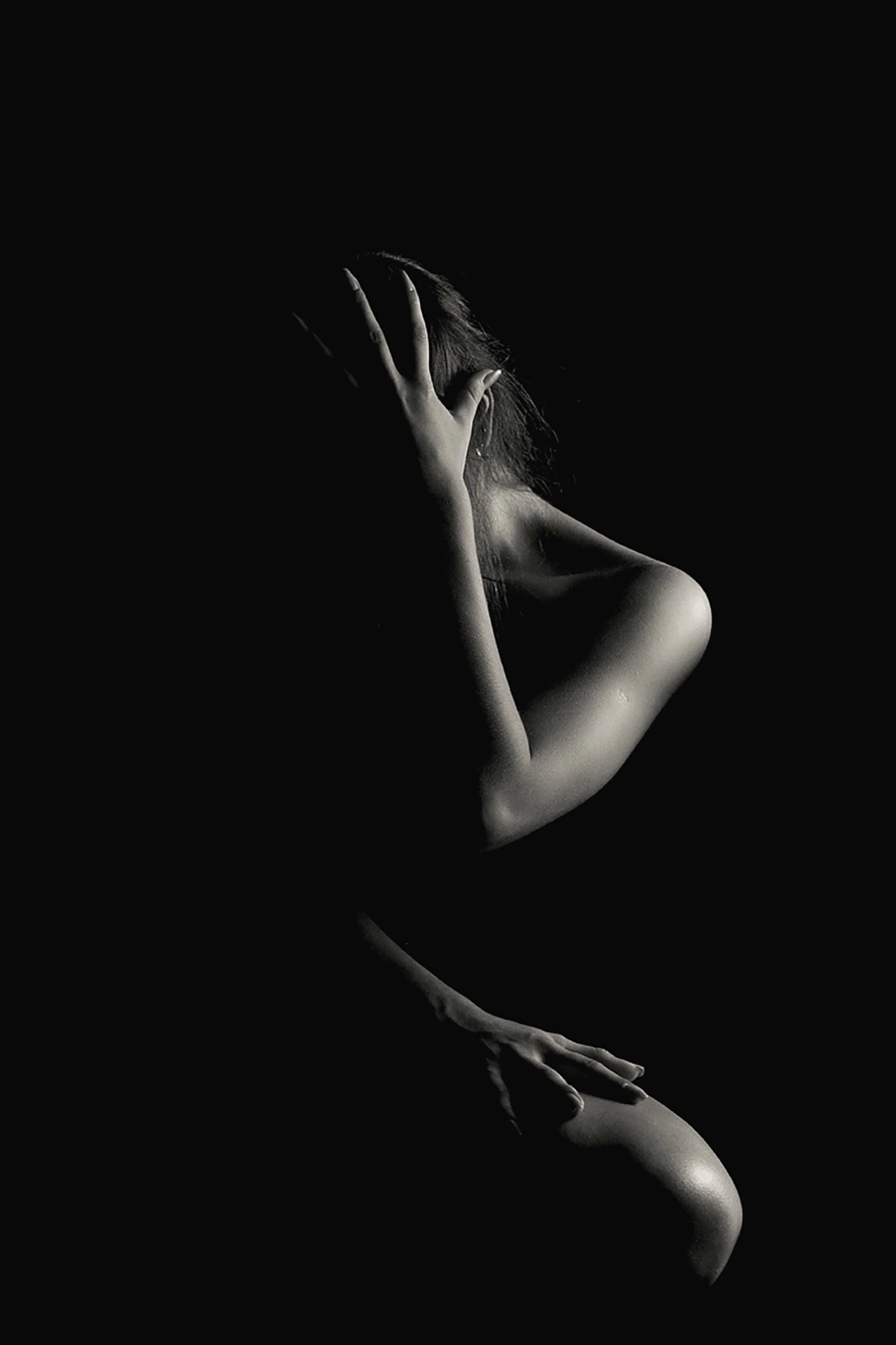 shoot-photo-nu-art-02 Silhouette féminine en clair-obscur, une main dissimulant le visage, capturée par David Polet Photography à Nice et Villeneuve-Loubet