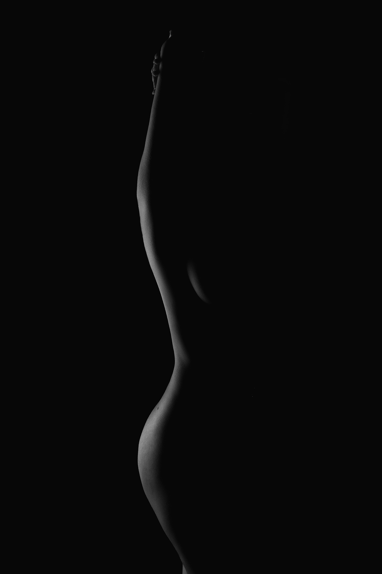 shoot-photo-nu-art-13 Silhouette féminine en clair-obscur, capturant l’élégance des courbes avec une lumière subtile.