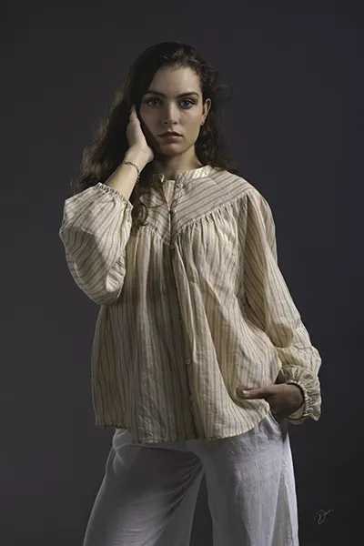 Portrait mode en studio d’une femme posant avec élégance, photographie professionnelle style fashion et lumière douce.