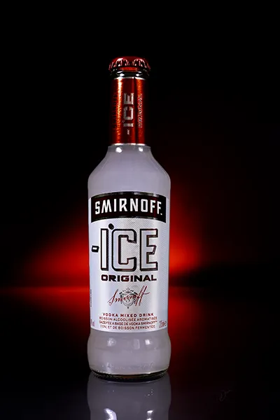 Bouteille Smirnoff Ice Original sur fond noir, photographie produit avec éclairage studio et ambiance premium.