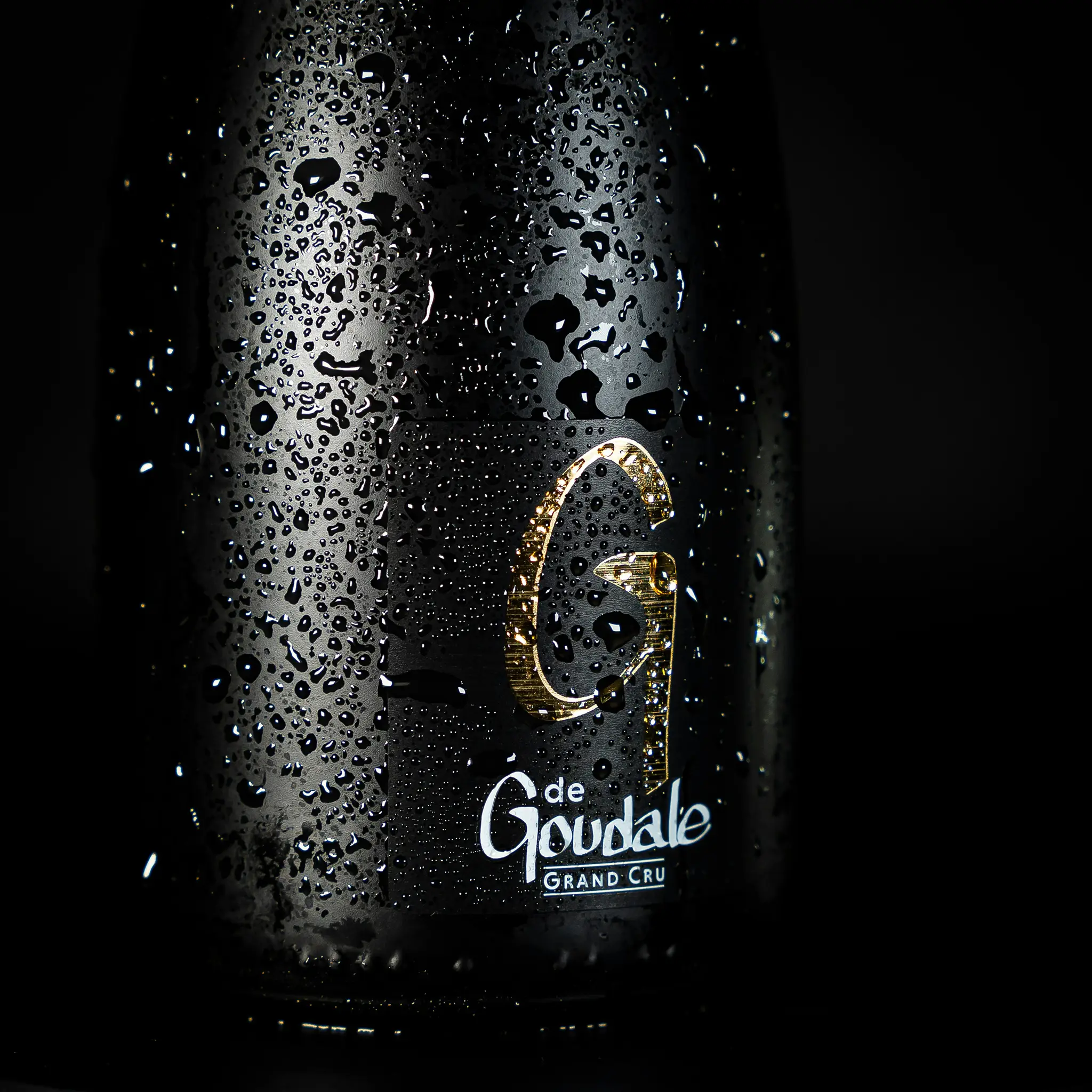 Packshot bouteille de bière G de Goudale couverte de gouttes d’eau sur fond noir, éclairage studio, photo publicitaire