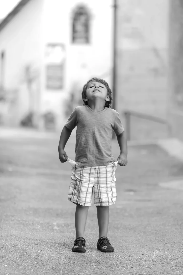 Portrait en noir et blanc d’un enfant lors d’un shooting enfant Côte d’Azur dans une ruelle.