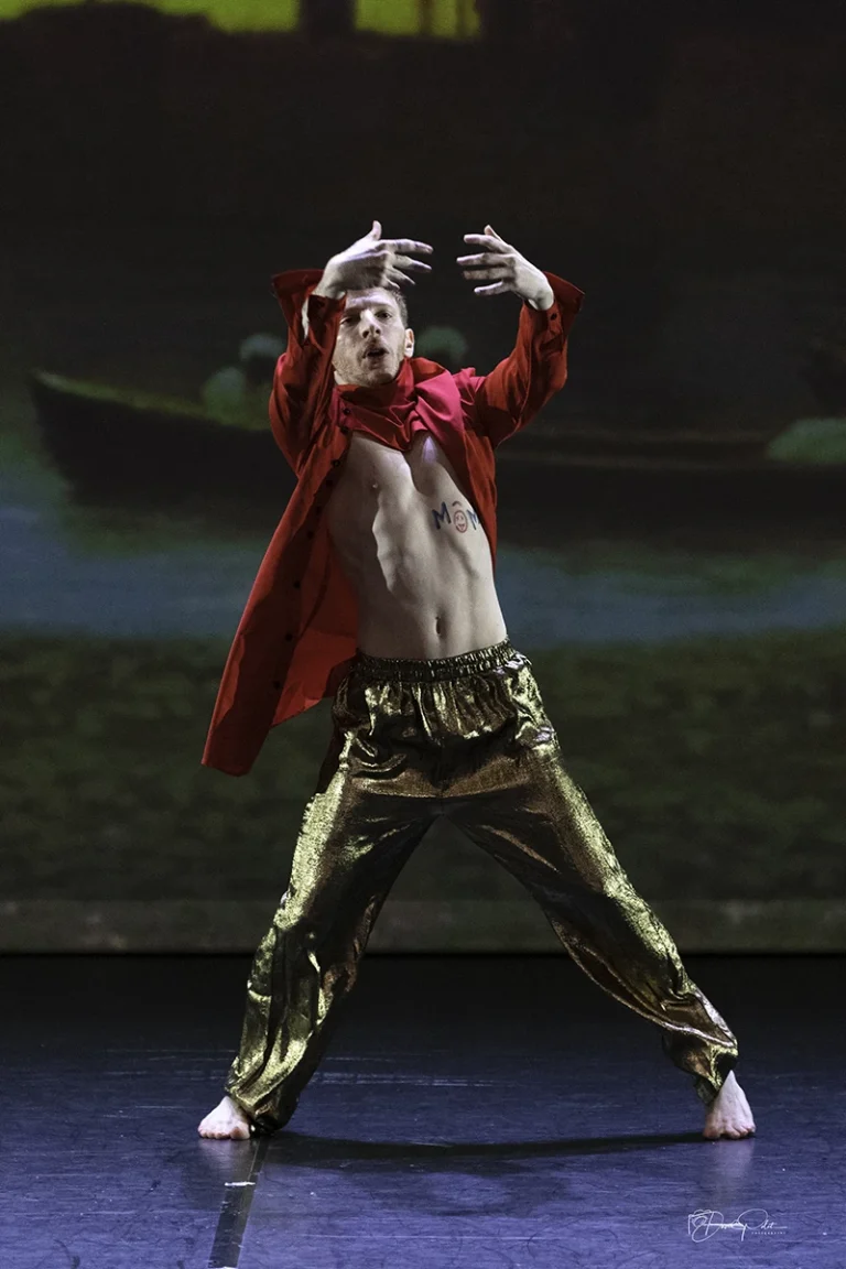 Danseur sur scène en costume rouge et or, photographe spectacle de danse, mouvement intense et expressif