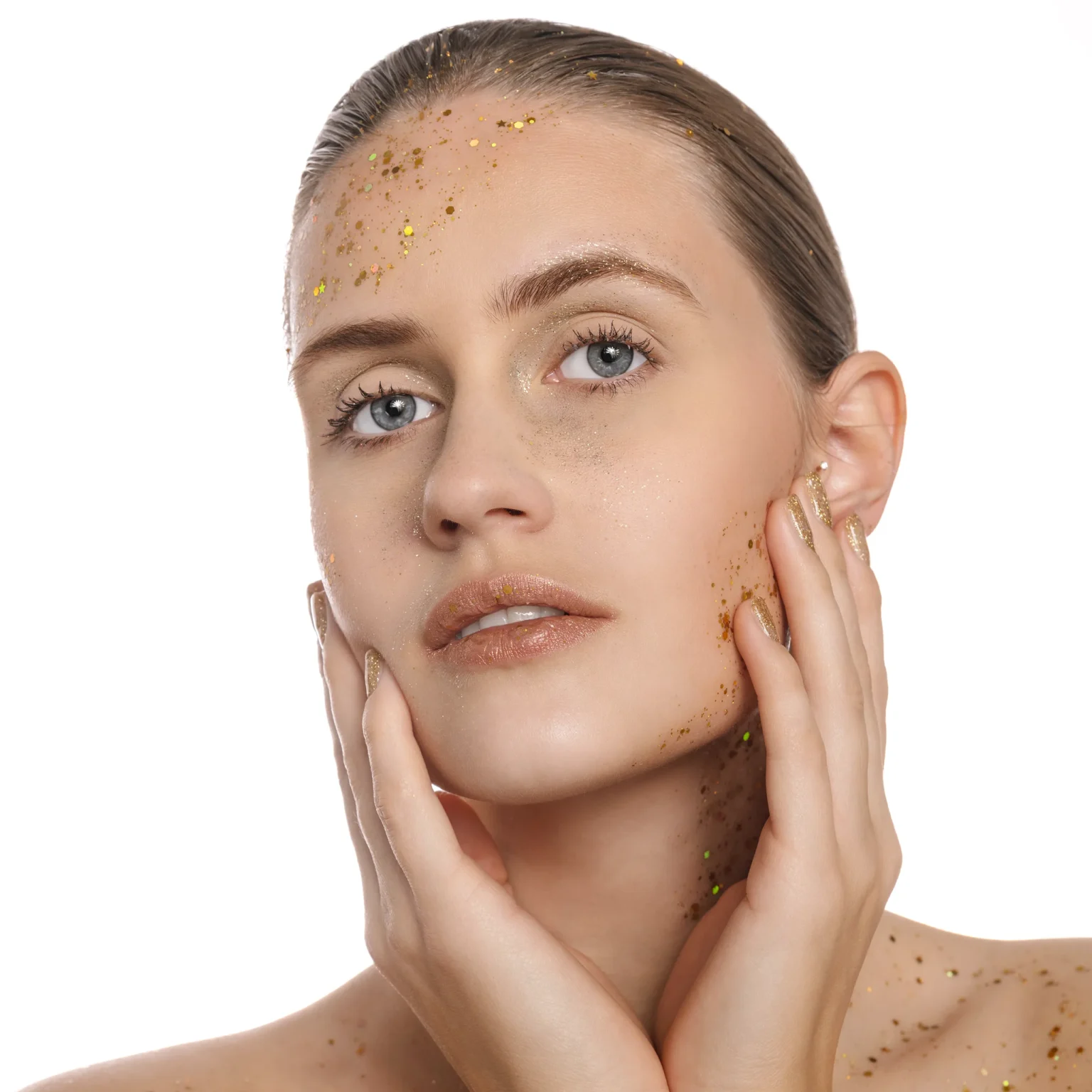 Portrait beauté en studio, visage lumineux avec paillettes dorées sur fond blanc, près de Nice