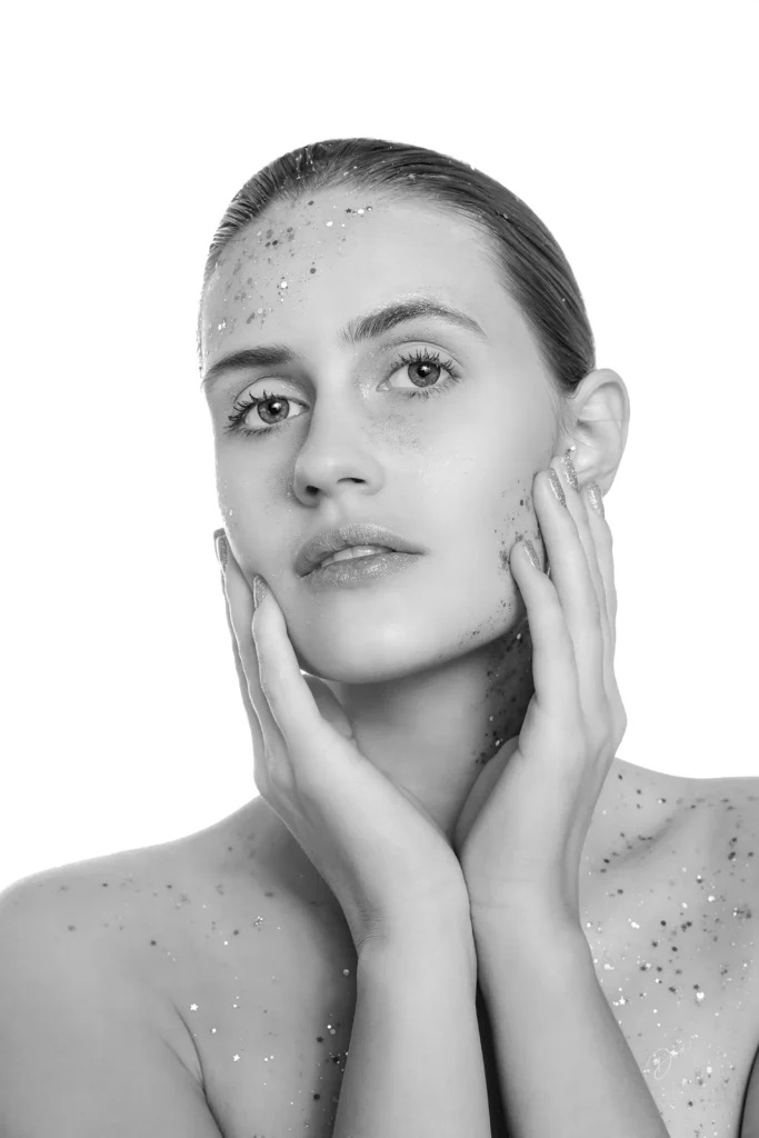 Portrait créatif nice : portrait beauté noir et blanc en studio, paillettes sur le visage, mains encadrant le regard