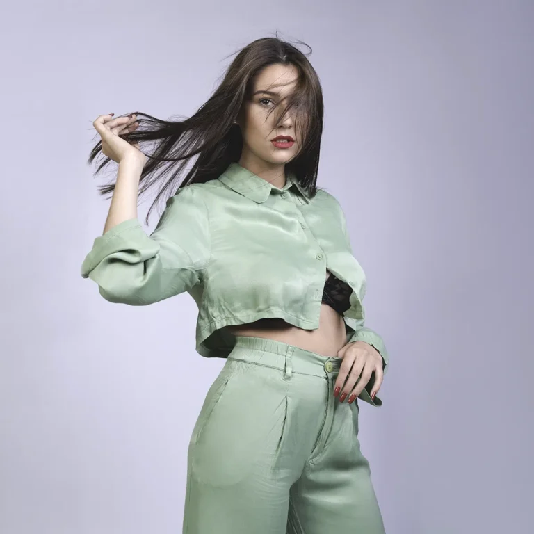 Modèle en tenue vert menthe en studio, cheveux au vent