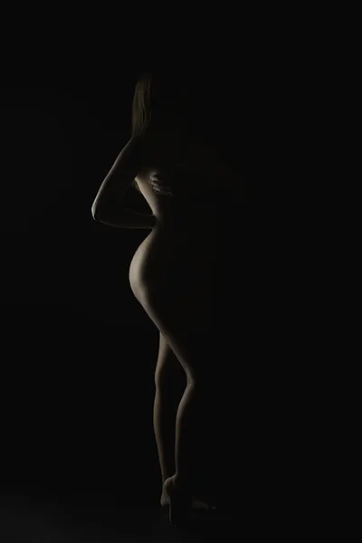 Silhouette artistique en clair-obscur, photo de nu artistique en studio réalisée par un photographe spécialisé en light painting.