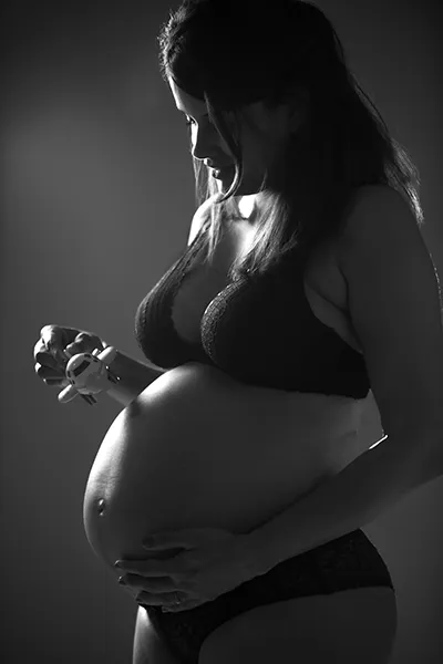 Photo grossesse en studio, femme enceinte en lingerie noire, portrait maternité artistique, photographie grossesse