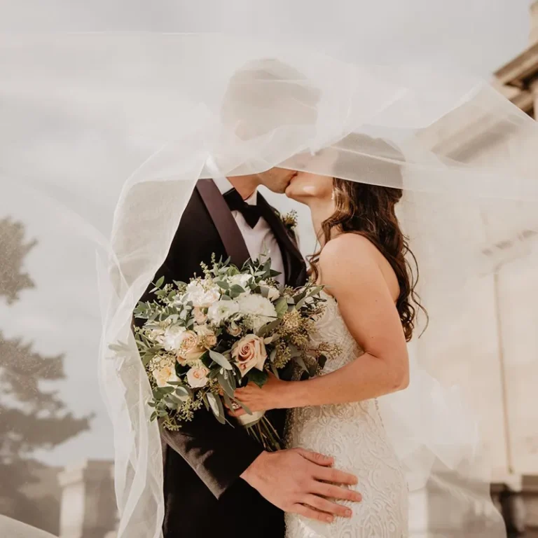 Mariés s’embrassant sous le voile, bouquet de fleurs, lumière douce – photographe de mariage Villeneuve Loubet