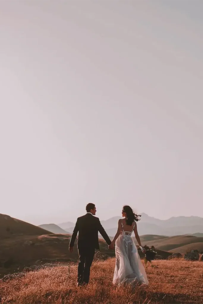 Couple de mariés marchant main dans la main au coucher du soleil, photographe de mariage dans les Alpes-Maritimes