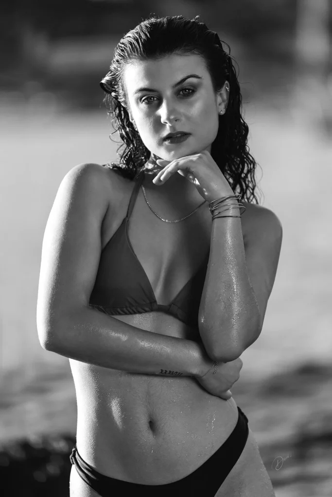 Portrait lifestyle Côte d’Azur : femme en maillot sur la plage, noir et blanc, regard intense, cheveux mouillés