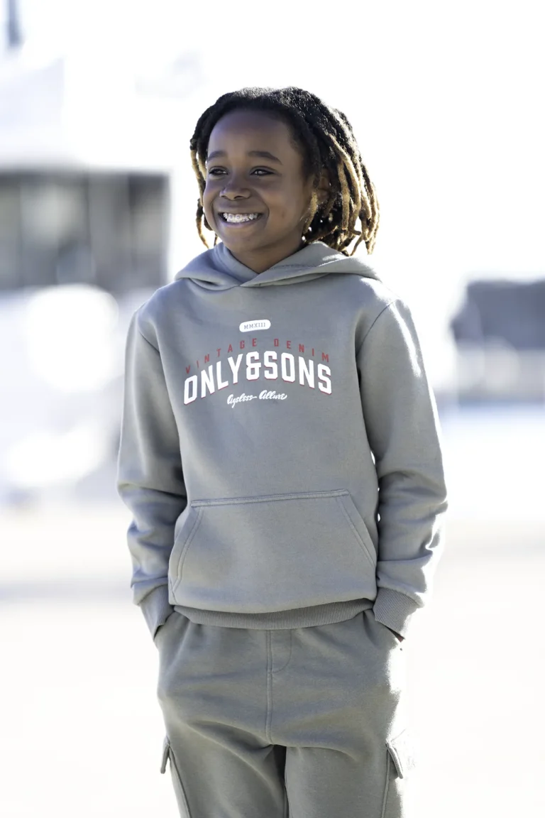 Book photo à Nice et Villeneuve-Loubet : portrait enfant souriant en hoodie gris, lumière naturelle, fond flou