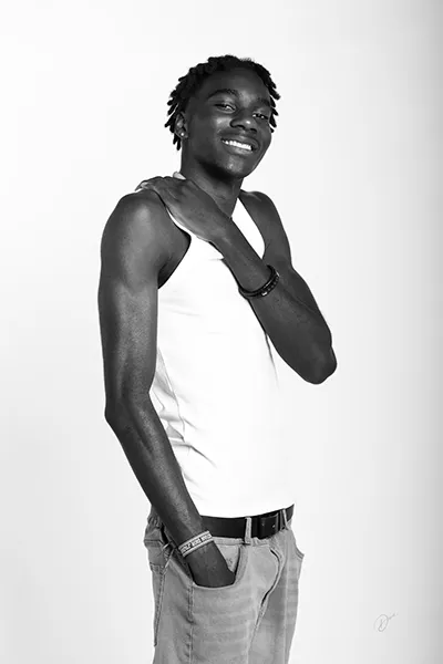 Portrait polas masculin en noir et blanc en studio, homme souriant photographié par un photographe professionnel.