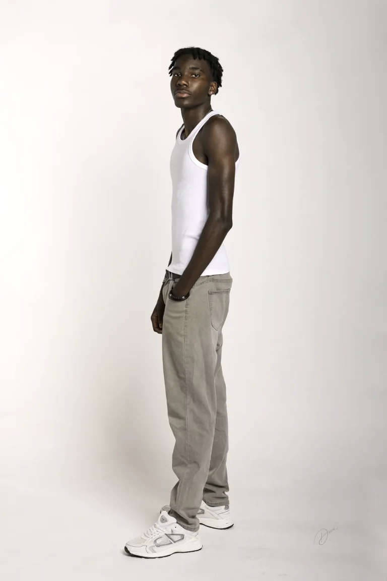 Photo polas studio fond blanc : modèle homme debout, tenue casual, vue 3/4, sneakers blanches