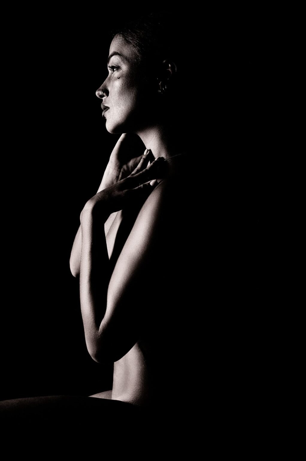 Nu artistique en studio avec portrait de profil en clair-obscur noir et blanc