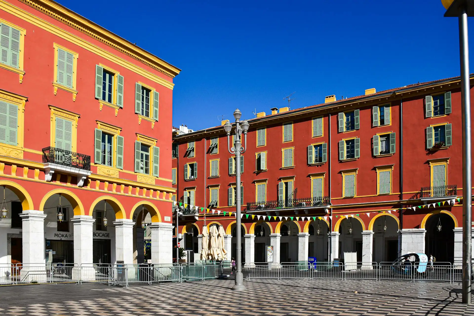 Place Masséna à Nice avec façades rouges et arcades, un spot photo urbain et graphique