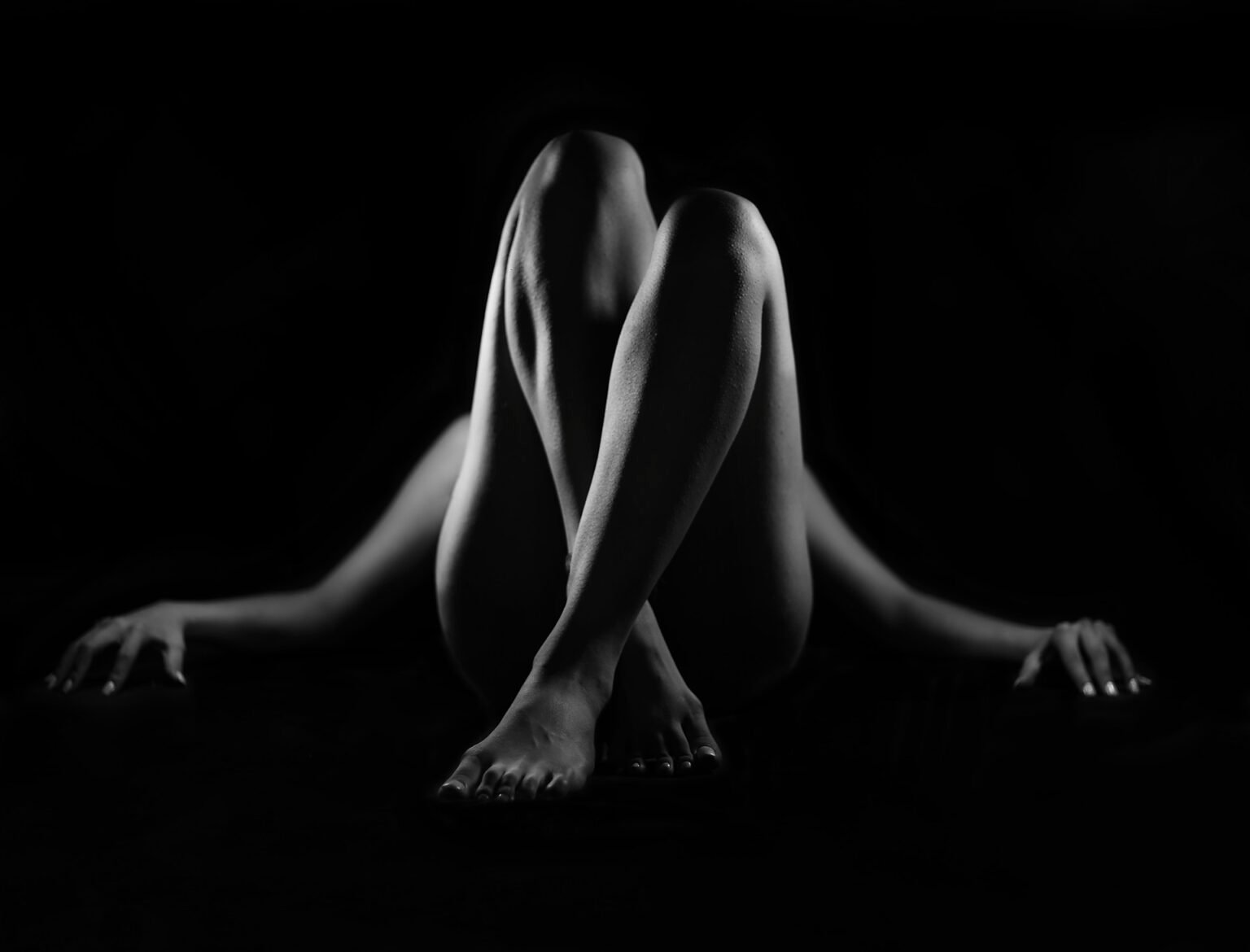 Première séance photo nu artistique en noir et blanc avec pose élégante en clair-obscur