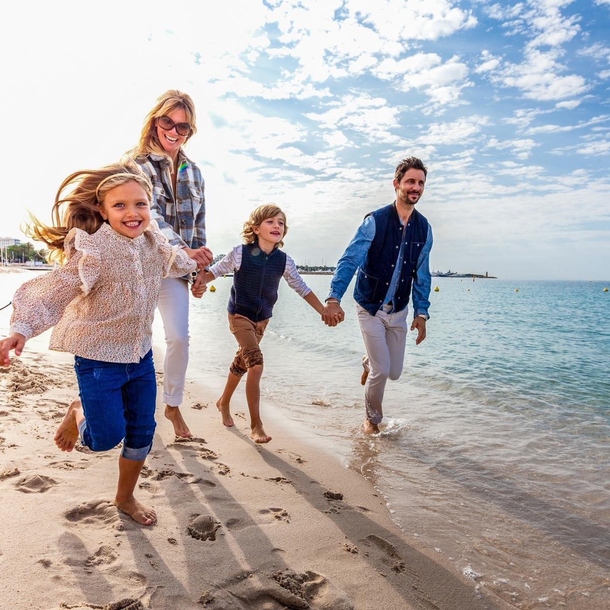 Famille en mouvement au bord de la mer pendant une séance photo sur la Côte d’Azur.