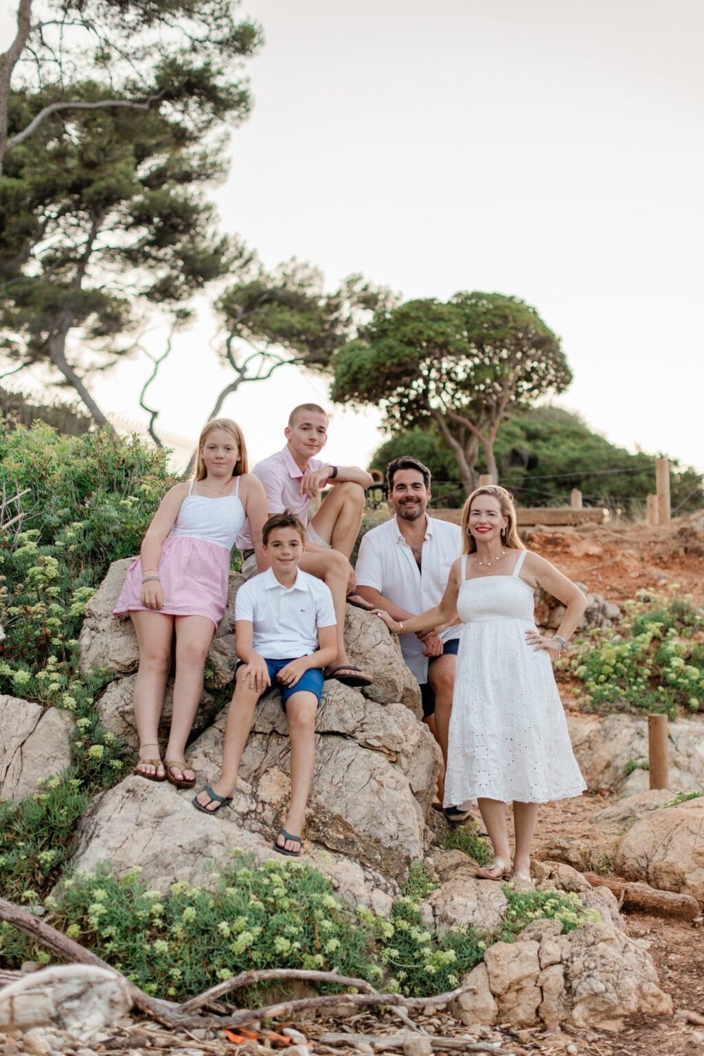 Famille réunie pendant une séance photo de vacances sur la Côte d’Azur dans un décor naturel méditerranéen.